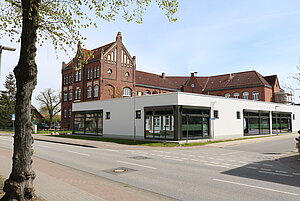 Foto der Regionalen Schule Grabow, ein neogotischer Backsteinbau mit modernem, schlichtweißem Anbau.